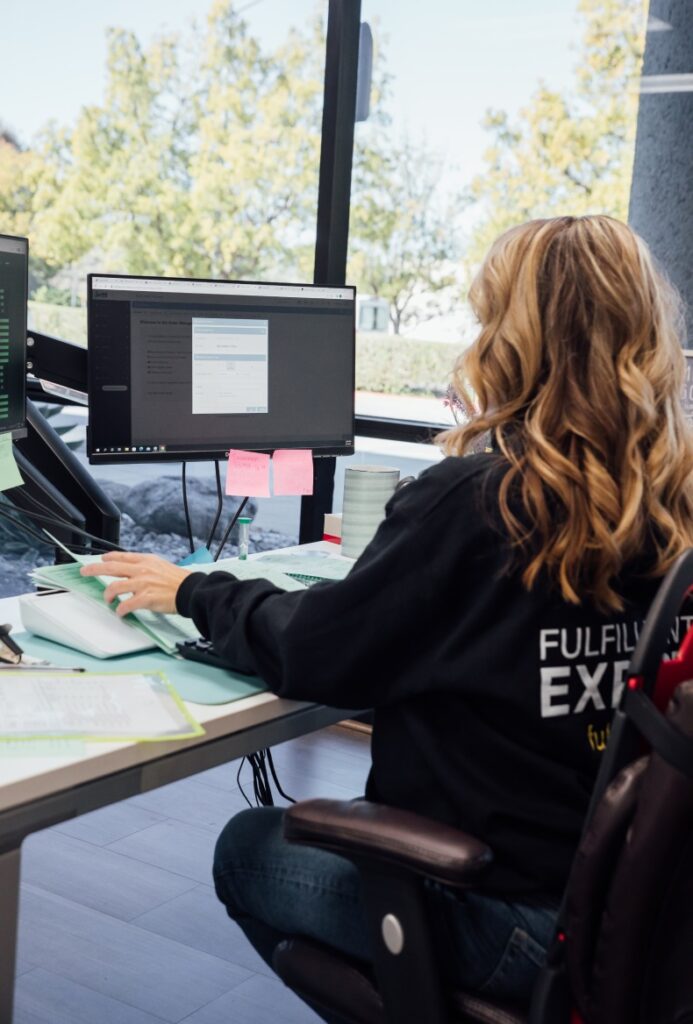 girl working behind a desk and PC.